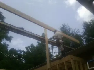 Carpenter setting a ridge beam over a new addition frame — Ice Dam Removal by Roofing Brothers in Bethany
